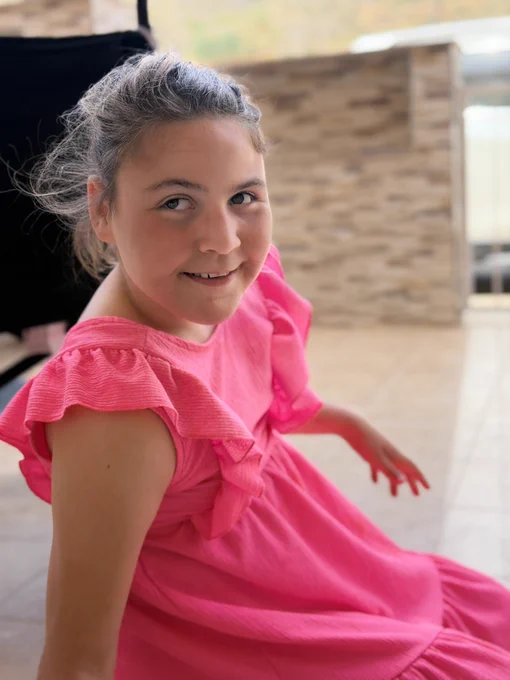 Mismo vestido y misma situación pero mira hacia el lado contrario y se gira para ver la cámara