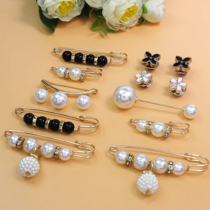 Elegant pearl waist cinching brooch pin set featuring decorative pearls, rhinestones, floral accents, and safety pin designs. Adjustable anti-slip fashion accessory for dresses, skirts, shirts, jeans, sarees, and women's clothing. ✨💎🤍