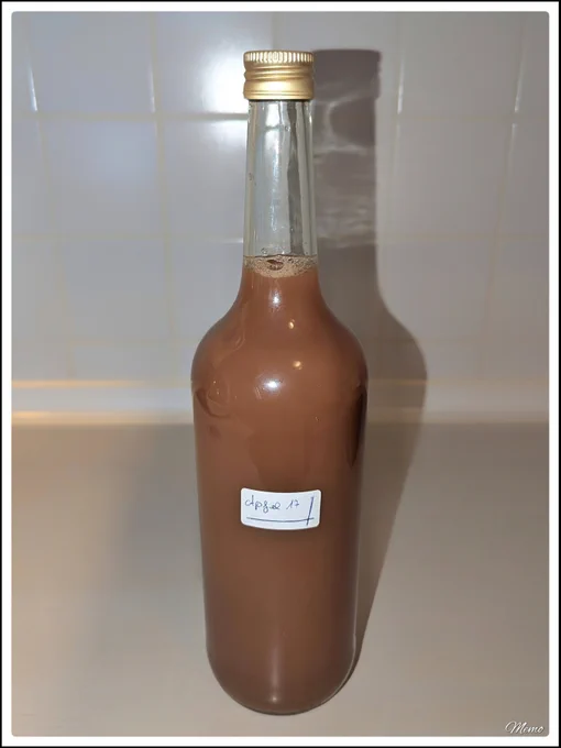 Bildbeschreibung: Eine Flasche mit Apfelsaft steht auf einer Küchenarbeitsplatte. 