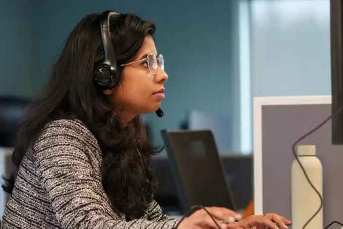 a woman wearing a headset behind a computer