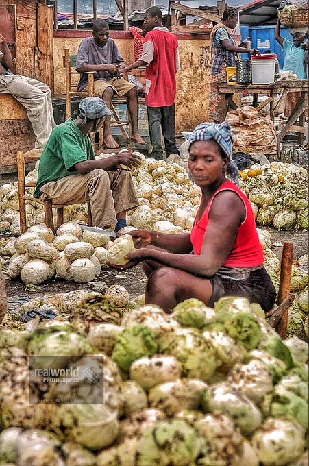 A woman sells cabbage at a massive market in Port-au-Prince, Haiti. Gary Moore photo. Real World Photographs. #streetphotography #Grok #photojournalism #Haiti #Nikon #poverty  #garymoorephotography #realworldphotographs   #travelphotography #documentary #photography