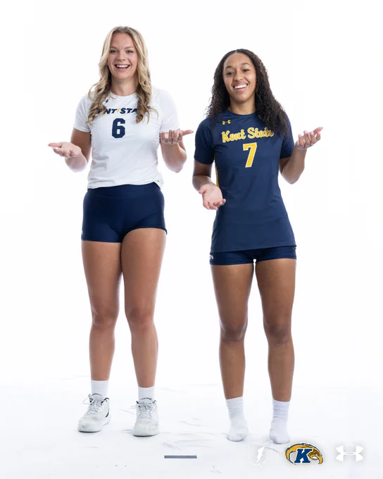 Two individuals wearing Kent State volleyball uniforms stand together, smiling. One wears a white jersey with the number 6, and the other wears a navy jersey with the number 7. The Kent State and Under Armour logos are visible at the bottom.