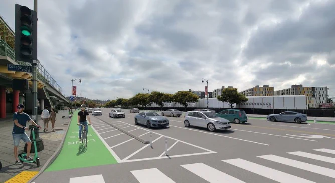 Urban street scene with cars waiting at a green traffic light and a cyclist riding in a protected bike lane beside pedestrians on the sidewalk.