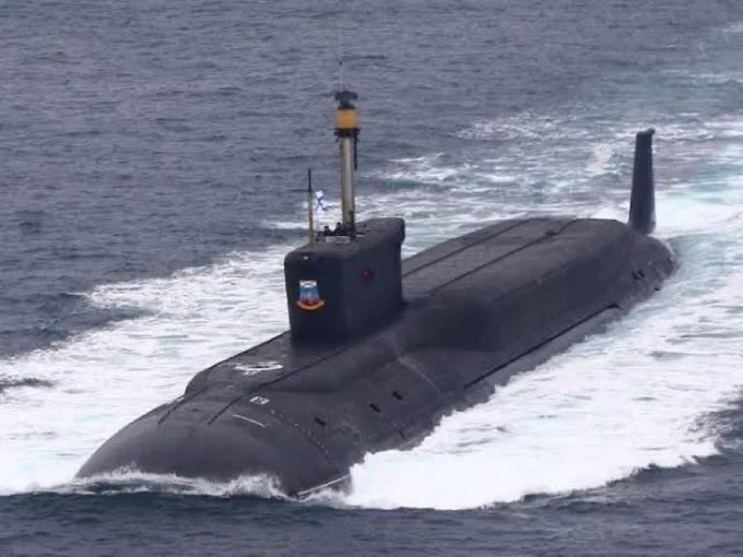 Russian Borei-class ballistic missile submarine (SSBN) underway on the surface, Russian Navy ensign visible on the sail. The Borei carries 16 Bulava SLBMs, each capable of delivering multiple independently targeted warheads. Eight are currently operational; two more Borei-A hulls are under construction. This is the boat that transits the GIUK Gap — the corridor where the U.S. just went dark. SOURCE: Russian Navy/public domain.