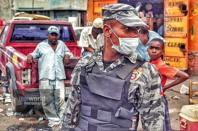 A Port-au-Prince police officer keeps his eye open for danger. Haiti. 2010. Gary Moore photo. Real World Photographs. #photojournalism #Grok #earthquake #history #Haiti #Nikon #police  #disaster #Getty #garymoorephotography #realworldphotographs  #documentary #streetphotography