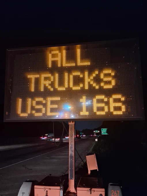 Changeable message sign that reads “All Trucks Use 166”