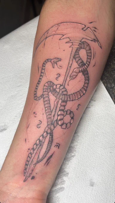 Tattoo of the Havok Scythe and the Ether Snakes, with "Iris" written in Onyx Runic.