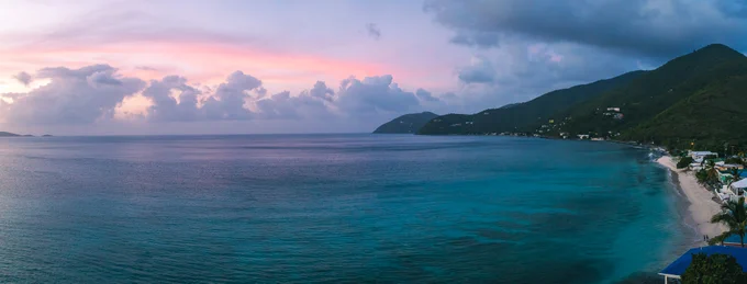 Turquoise beach with mountains in the sunset
