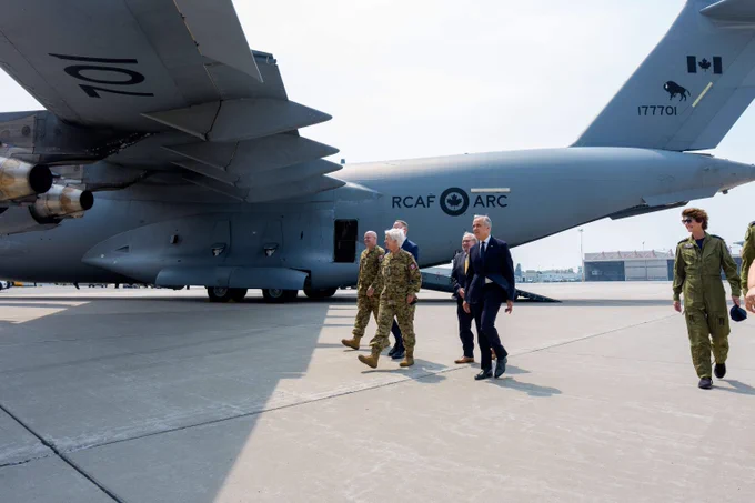 Le premier ministre Mark Carney marche aux côtés de membres des Forces armées canadiennes sur le tarmac de la BFC Trenton.