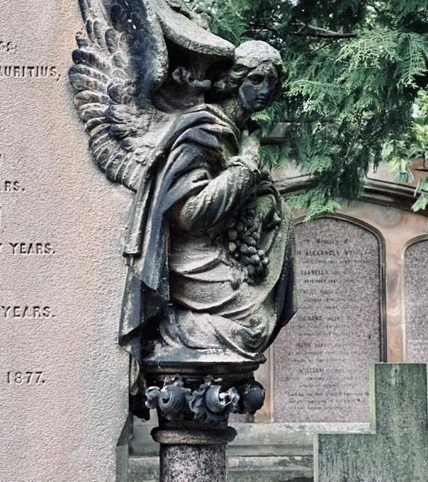 Headstones and a sombre, carved angel, stained over time.