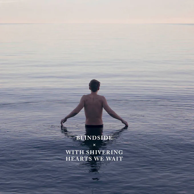 Album Art of Blindside's With Shivering Hearts We Wait album - On a very calm lake or ocean that stretches to the horizon, a young man is standing shirtless in the water up to his waist, and his hands are outstretched on each side just so that his fingers are touching the top of she water. He's looking away from the camera towards the never-ending water and the horizon, which has ha bit of a pink hue to it like it is magic hour. Printed in the bottom middle is the band's name in white text, followed by a small 'x' and then the album title in the same font.