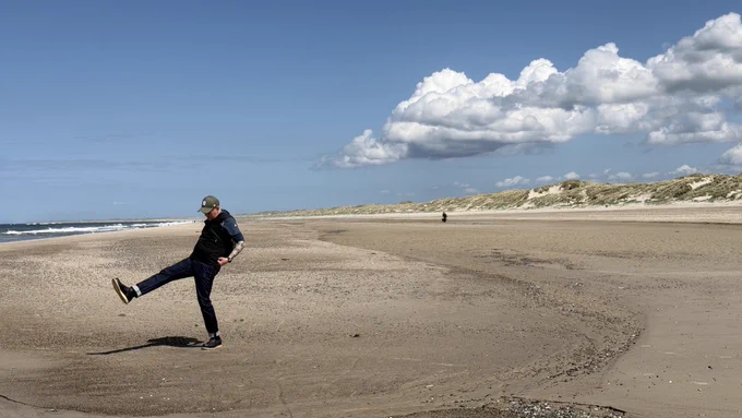 Strand und Dünen und Wolken. Links im Bild der User hinter dem Account wie er Faxen macht.