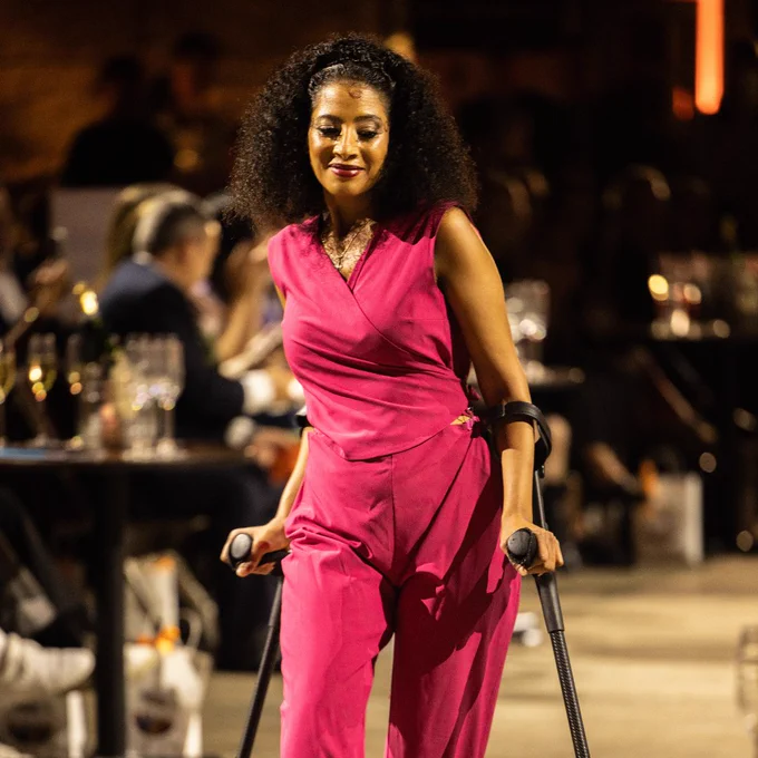 Photo of model Susan wearing a pink jumpsuit on the Front Row runway. 