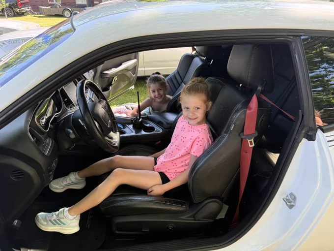 Two children sit inside the OSHP forfeited Dodge Challenger Hellcat at the Toledo Police Museum Cops and Rodders Car and Bike Show.