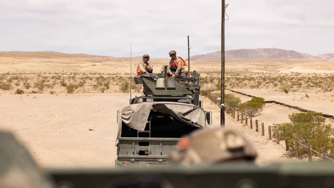 Marines travel in a convoy of tactical vehicles across a desert training range during motorized operations training.