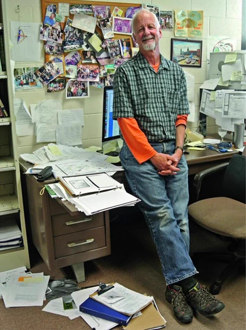 Chris Uhl standing next to his desk while he was a professor at Penn State. 