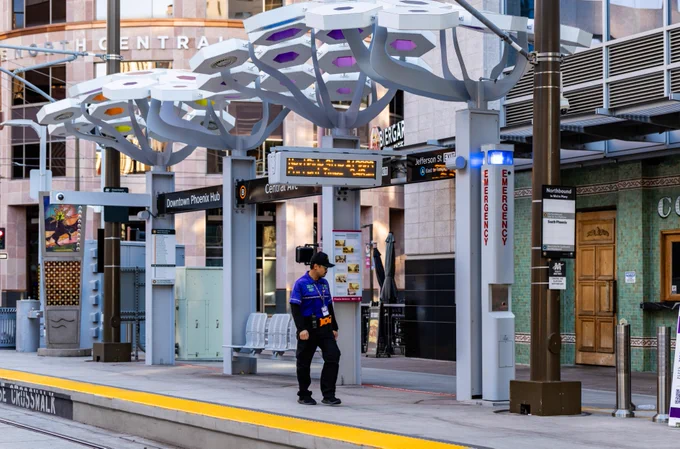 A Valley Metro Security Guard is standing by a light rail platform in Downtown Phoenix. 