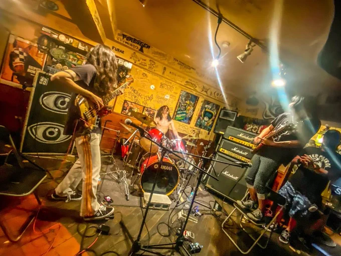 An action shot of the three members of Green Milk from the Planet Orange in the middle of a performance.