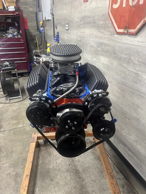 Small block 350 engine outfitted with updated serpentine belt system. Aluminum intake powder coated black to match valve covers and air cleaner. All installed and mounted to engine and stand.