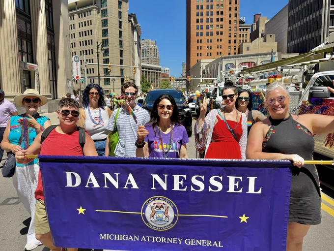 AG Nessel, DAG staff pose with parade banner