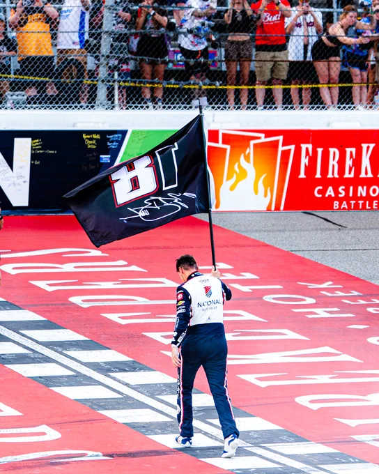 Denny Hamlin carries a flag for Kyle Busch after winning at Michigan.
