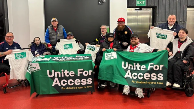 Manchester United Disabled Supporters' Association members, holding green 'Unite For Access' banner and branded t-shirts.