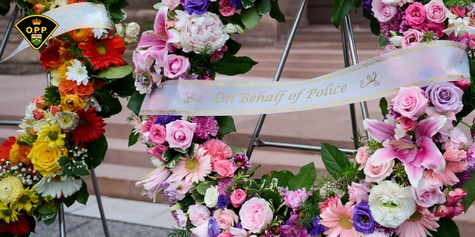 Floral wreath with ribbon which reads On Behalf of Police present at the Ontario Police Suicide Memorial