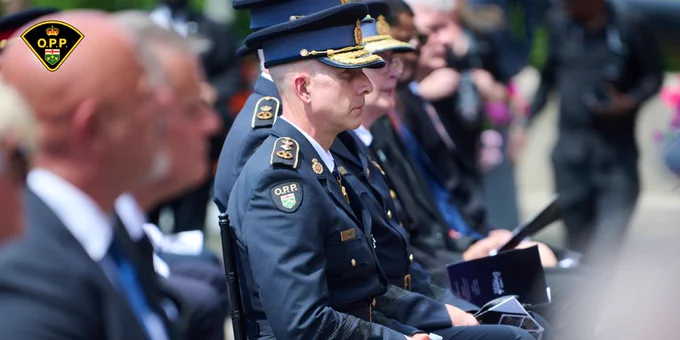 OPP Commissioner Thomas Carrique seated next to those in attendance at the Ontario Police Suicide Memorial