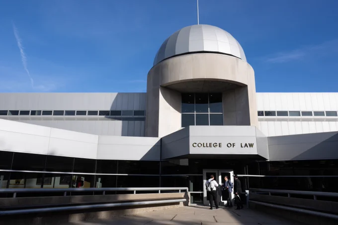 Modern College of Law building with a distinctive dome and clear blue sky above.