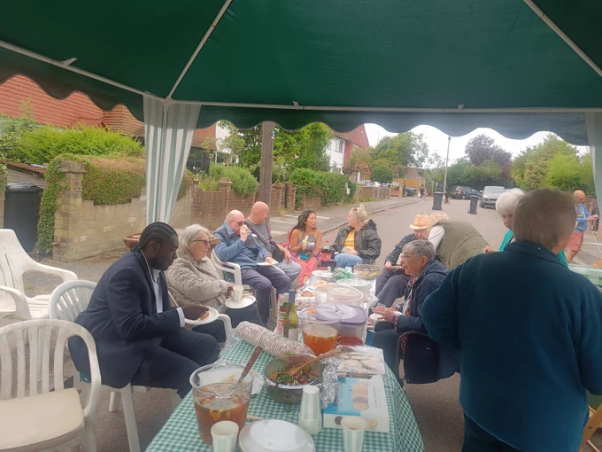 Photo of a group of people at a street party in Lewisham. Jug of Pimm's in foreground.