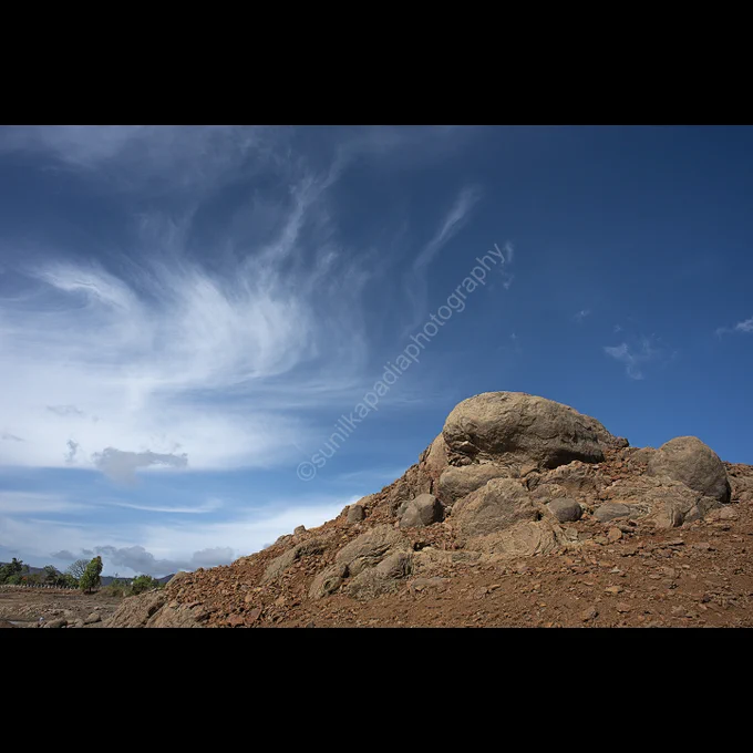 A color image of a landscape of hard rocks in the foreground and the soft dramatic clouds in the sky giving a wonderful contrast of nature. Pawna, Pune, Maharashtra, India
I shot this image to depict the contrast between the soft and smooth clouds and the hard and rough rock hill.
To buy this photo art print please message me here for more details and specifications. 

