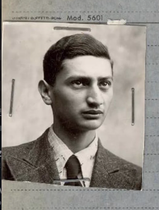 Vintage black and white portrait of a man in a suit and tie. The image is held in an album with metal fasteners.
