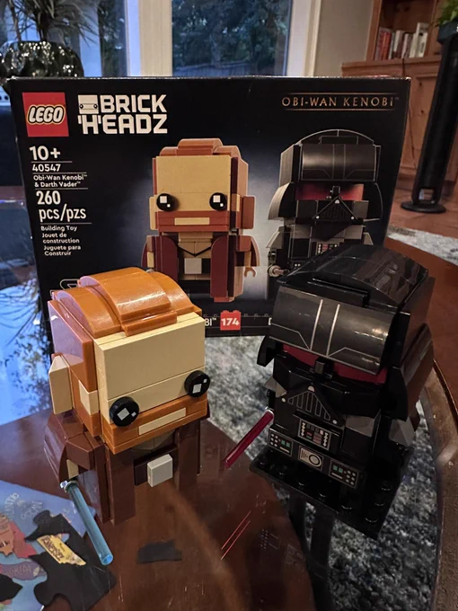 Photograph of two completed Lego figures, one of Darth Vader and one of Obi-Wan Kenobi, from the Lego “Brick Headz” collection so the heads are cutely oversized.  Kinda like Funko POPs.  The box for the set is standing behind them.