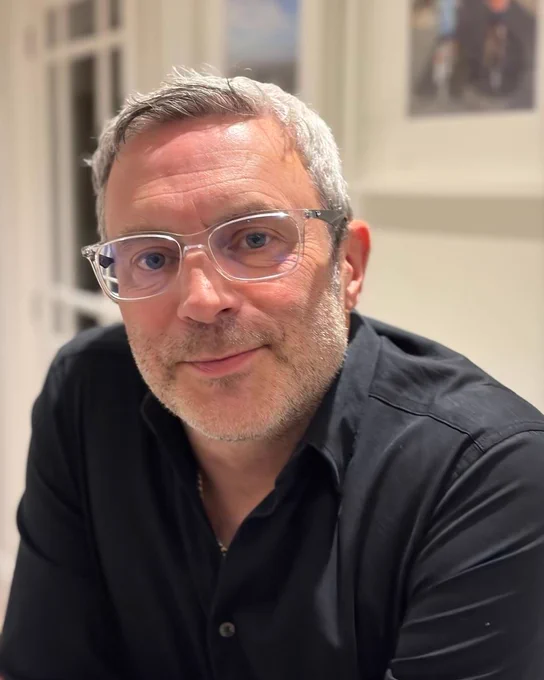 Image of Richard Bounds. Richard wears a black top, glasses with grey hair