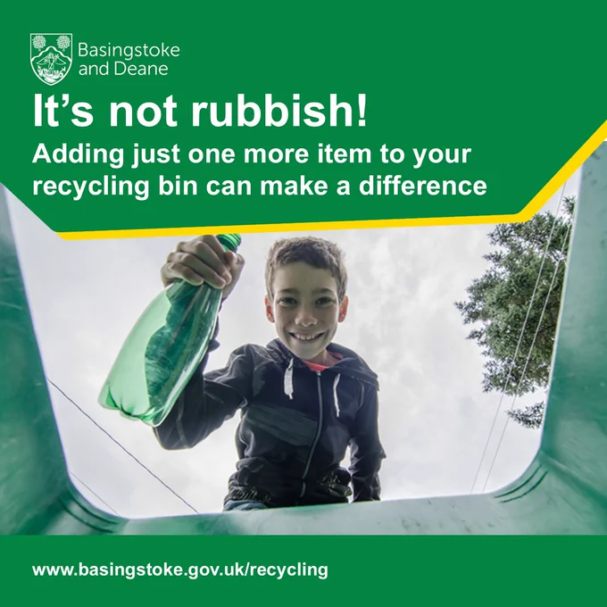 A smiling boy holds a plastic bottle over a recycling bin, encouraging recycling.