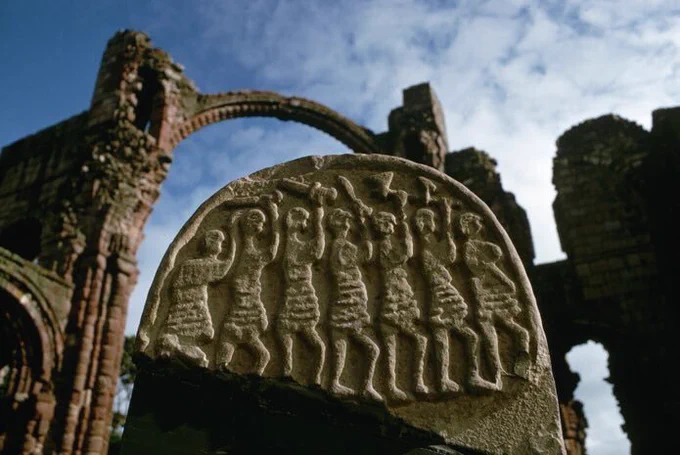 The ninth-century grave marker found at Lindisfarne, known as the Viking Domesday stone, carved on one side with seven men brandishing weapons.
