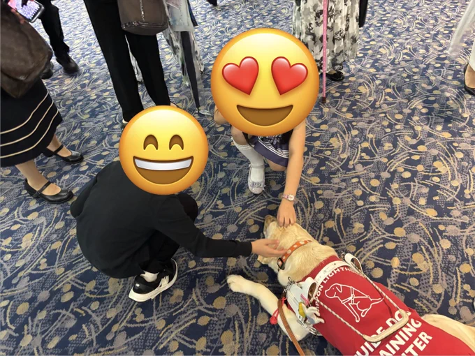 女の子、男の子に頭を撫でられているデモレッドのオリナ。オリナも中に顎をつけて気持ちよさそうな様子。