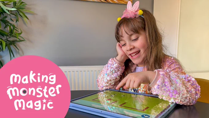 A girl happily playing Teach Your Monster to Read on an iPad with the words 'Making Monster Magic’
