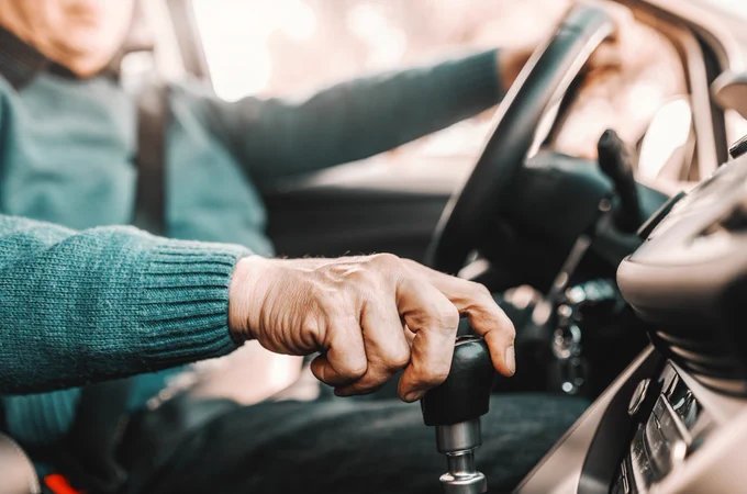 Une personne âgée au volant, la main sur le levier de vitesses