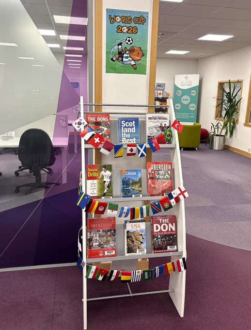 Football themed book display with the header World Cup 2026 and bunting of flags from the countries taking part in the World Cup.