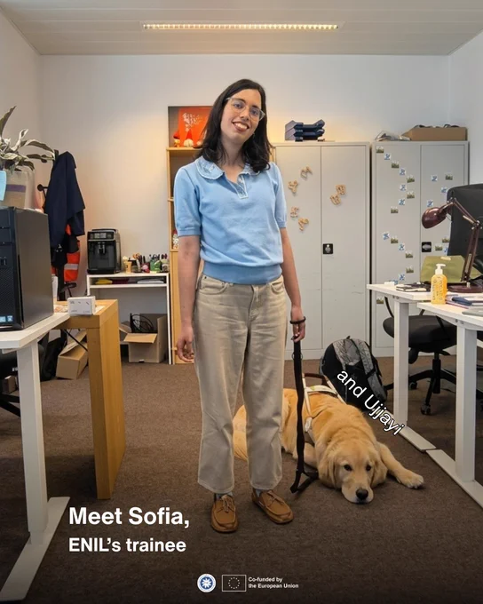 **Alt text:**
A portrait-style graphic introducing Sofia, ENIL’s trainee. Sofia stands smiling in an office, wearing glasses, a light blue top and beige trousers. A golden guide dog lies on the floor next to her, with the text “and Ujjayi!” placed near the dog. White text at the bottom reads: “Meet Sofia, ENIL’s trainee.” The ENIL and EU co-funded logos appear at the bottom.
