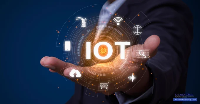 A person in a suit holds out their hand, displaying a glowing IoT (Internet of Things) graphic surrounded by icons representing technology, load cells, and connectivity on a digital interface.