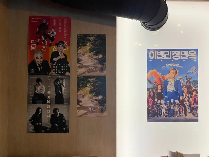 왼쪽에는 드랙X남장신사의 포스터가, 가운데에는 영극 모린의 포스터가, 오른쪽에는 이반리장만옥의 포스터가 나란히 붙어있다.