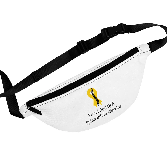 Proud Dad Of A Spina Bifida Warrior Fanny Pack with Adjustable Strap. The fanny pack is white with adjustable strap. There is a yellow ribbon with a black spine running down the middle of the ribbon in the front of the fanny pack. There is text underneath the ribbon that says Proud Dad Of A Spina Bifida Warrior.
