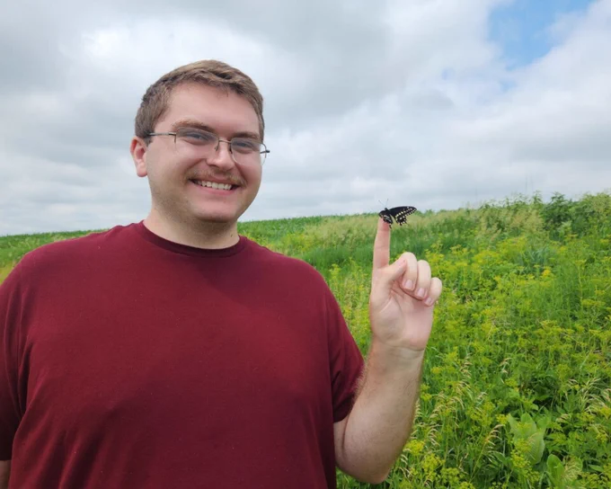 Paxton holding a swallowtail butterfly on his finger.