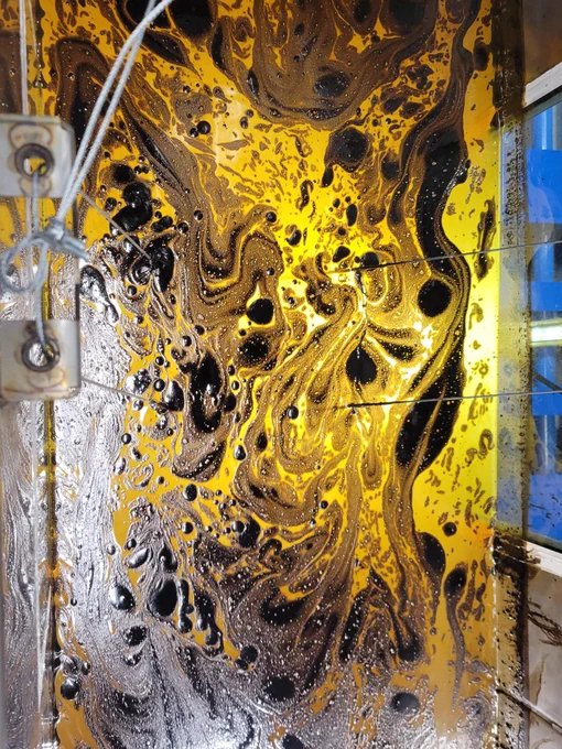 Yellow and brown swirl-like shapes from light crude oil floating  inside the simulator.