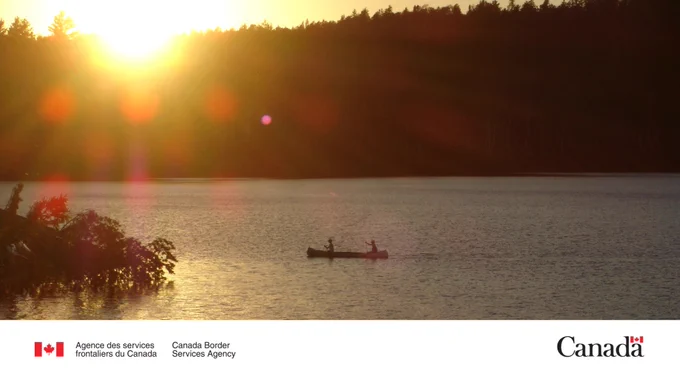 Deux pagayeurs devant une zone boisée au coucher du soleil au parc provincial Quetico.
