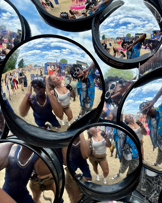 An image of three people standing in front of a mirrored wall at Mighty Hoopla festival.