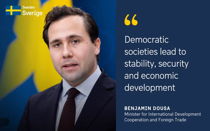 Portrait of Benjamin Dousa, Minister for International Development Cooperation and Foreign Trade, with a quote: "Democratic societies lead to stability, security and economic development".