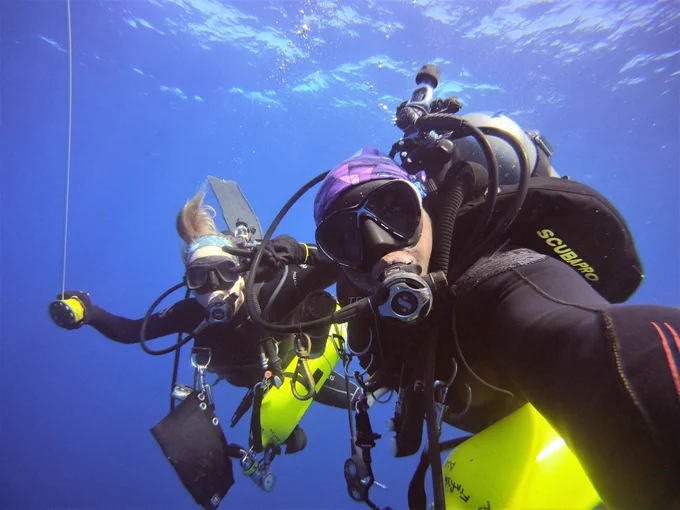 Colin Howe taking a selfie with someone else while scuba diving in the ocean.